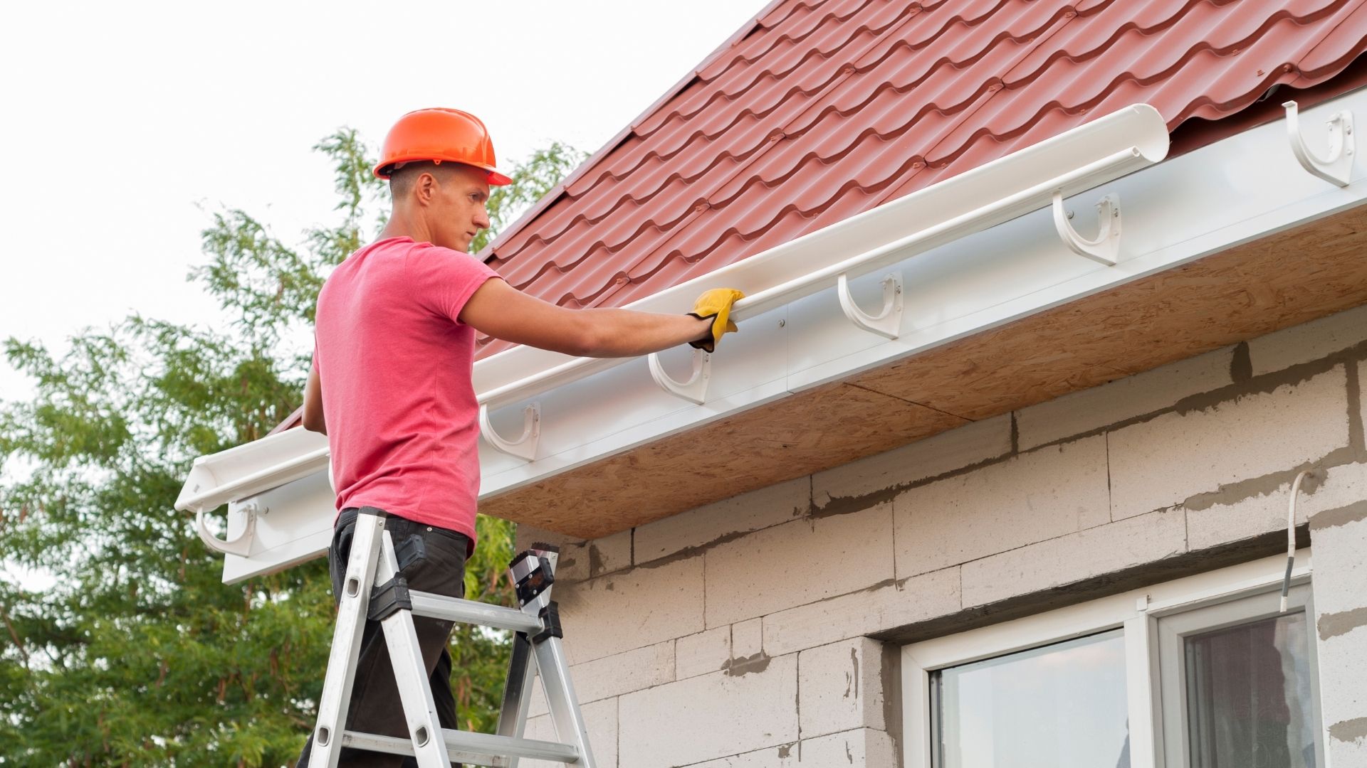 professional standing on ladder installing new gutter