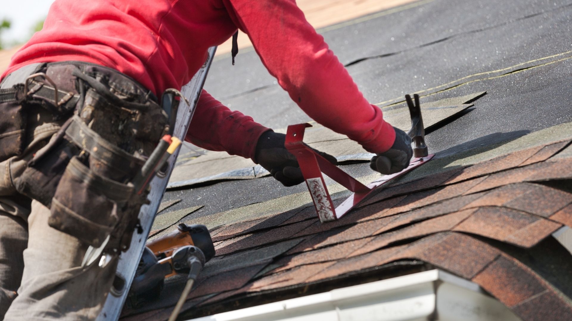 professional working on roof home while on ladder